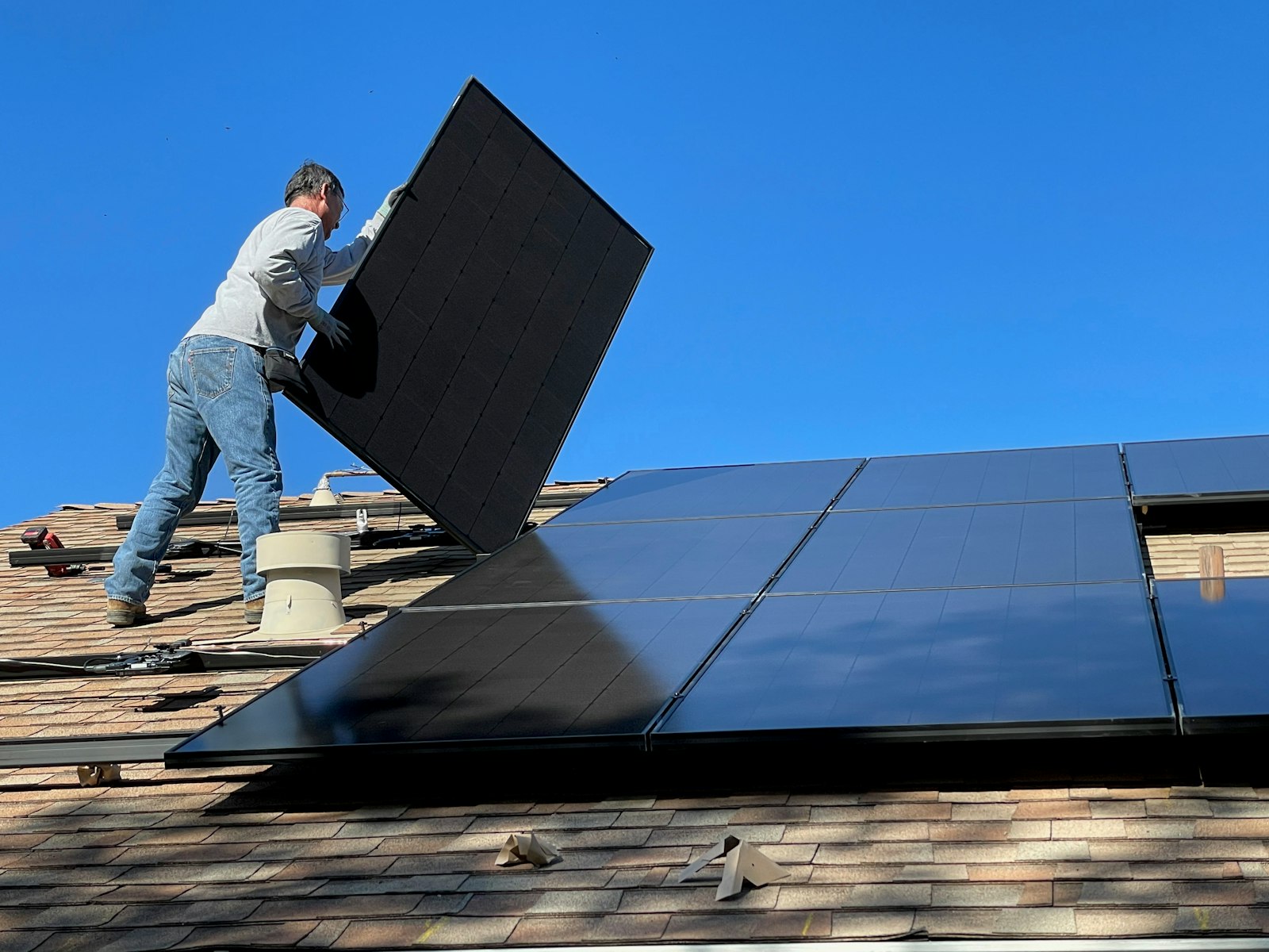 Technician checking a solar panel installation on a roof